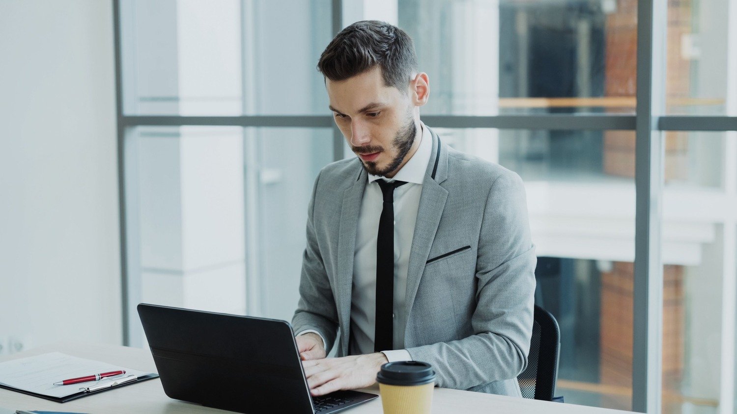 Man working on laptop, professional office setting